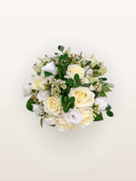 Reine Blanche S, roses ivoire, lisianthus blancs et fleurs de cire parmi un feuillage vert