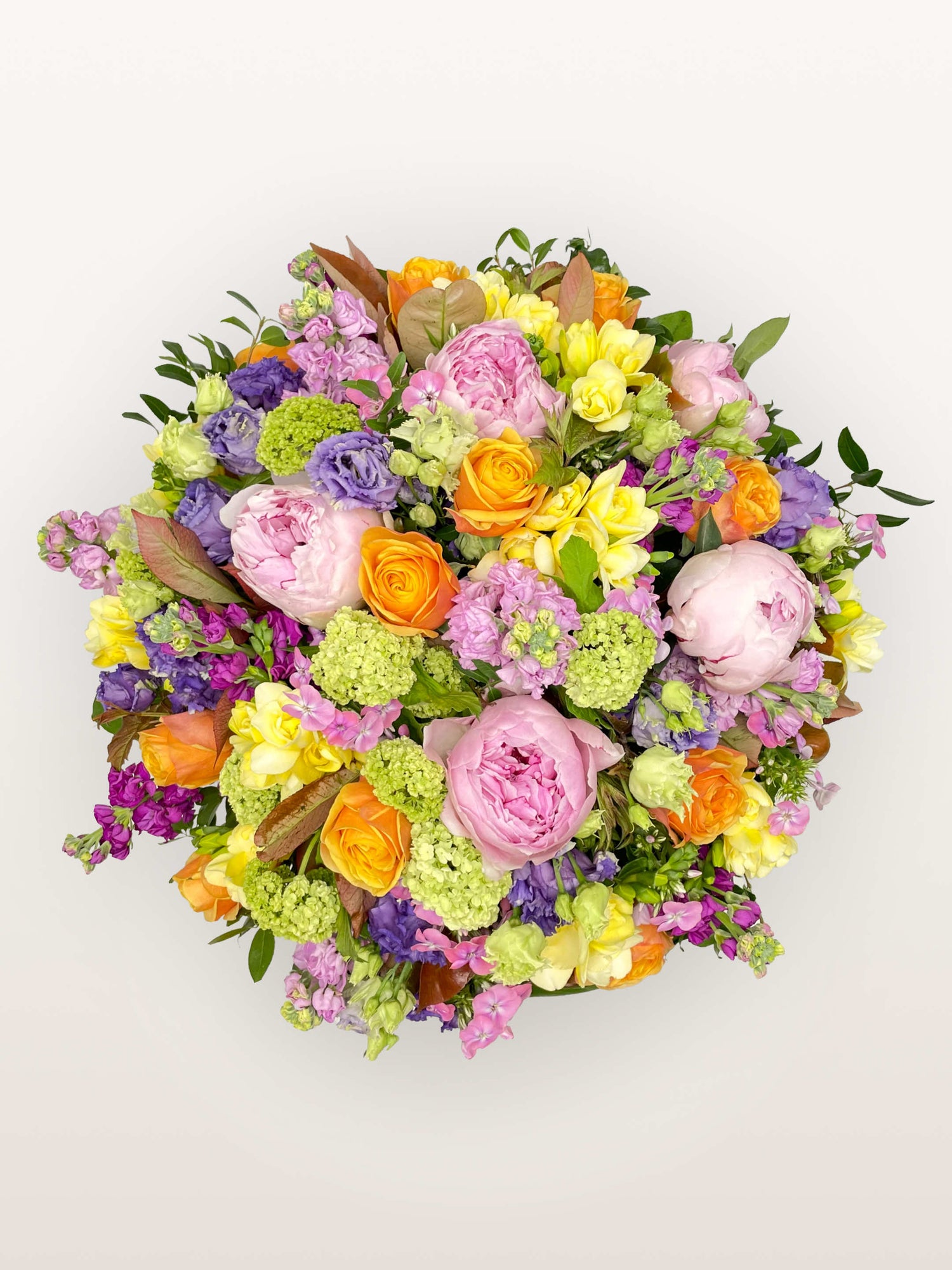 Oiseau de Paradis XL déploie pivoines roses, roses orange, freesias jaunes et lisianthus violets en un bouquet rond éclatant