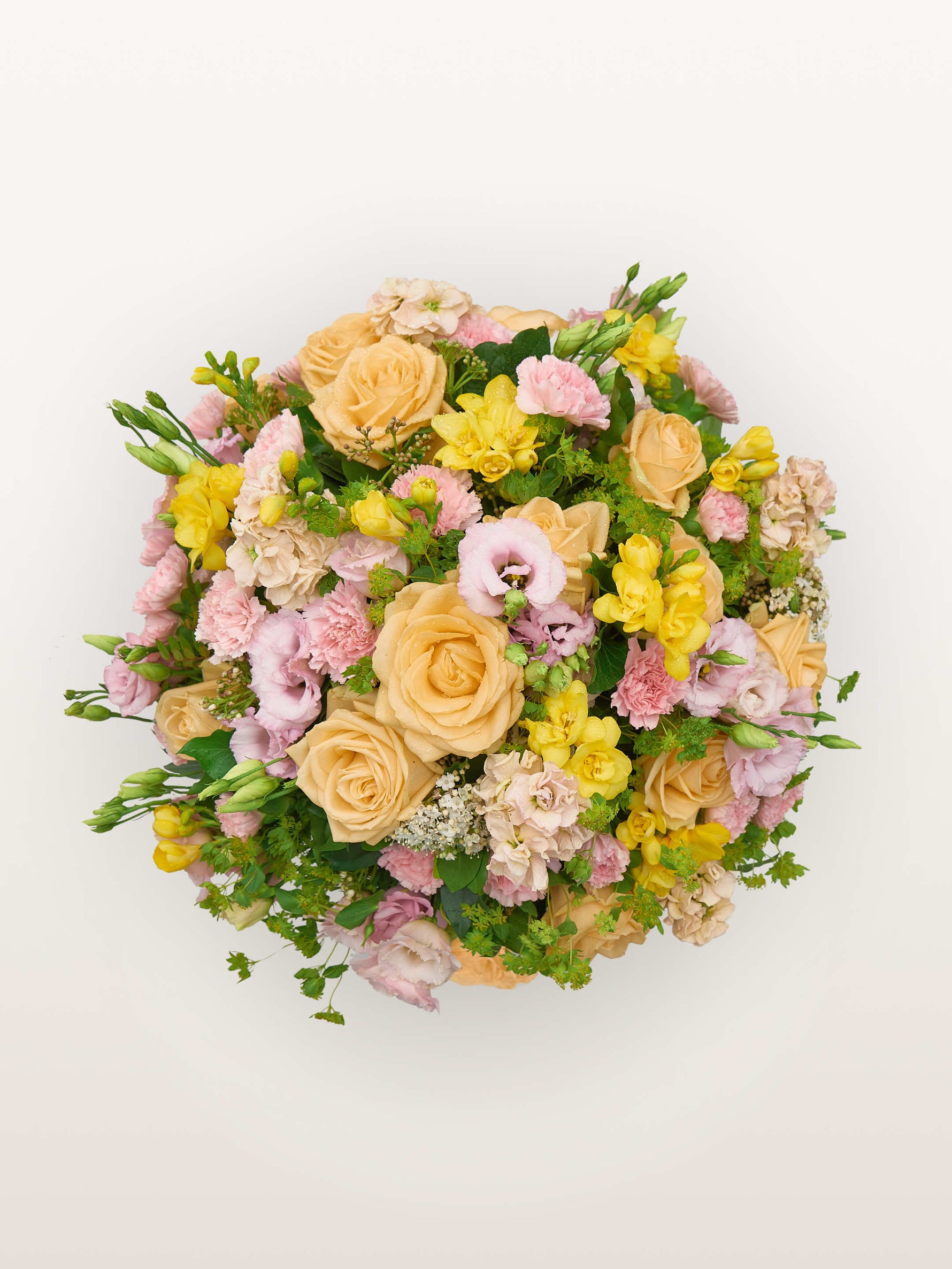 Point du Jour M, roses abricot, lisianthus rose, freesias jaunes et œillets roses en dôme fleuri