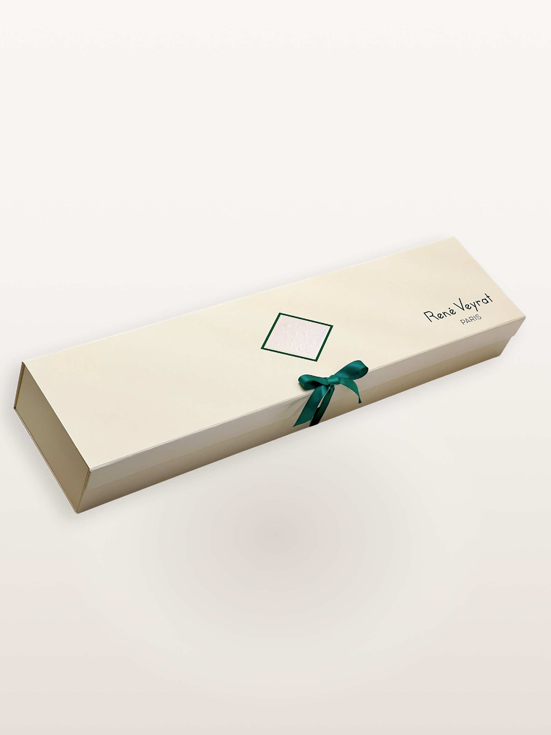 Coffret Princesse ivoire fermé, ruban vert sarcelle noué en nœud sur motif floral gaufré