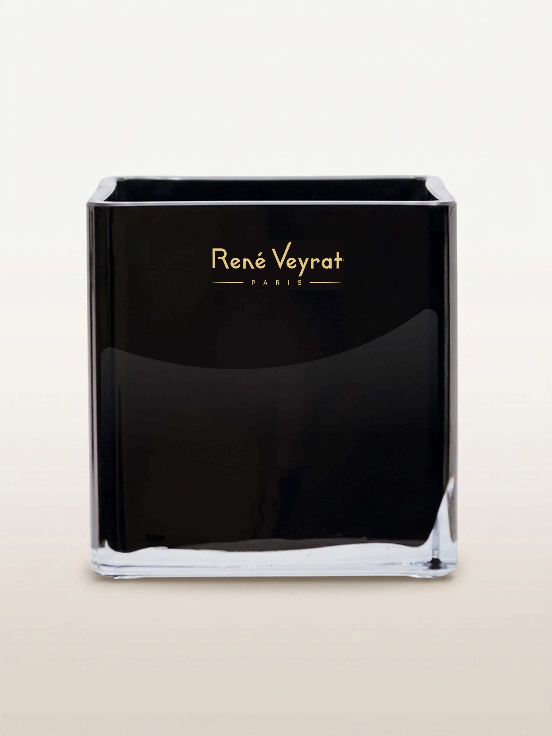 Contenant en verre noir de forme carrée, logo doré René Veyrat Paris centré sur la façade