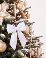 Branche du sapin de Noël Grand Apparat Sacré-Cœur : nœud de satin blanc, poinsettia ivoire, boules dorées 