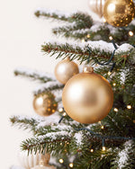 Branche du sapin de Noël Parure Sacré-Cœur : boules or et ivoire, guirlande blanc chaud et neige artificielle 